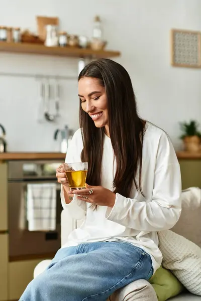 Young woman relaxes at home, sipping herbal tea and enjoying the peaceful atmosphere. — Stock Photo