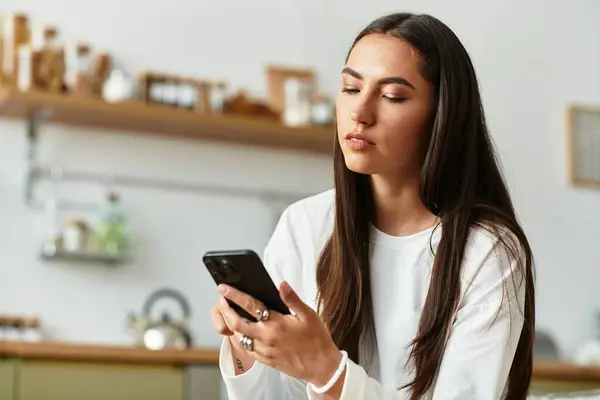 Beautiful young woman takes a moment to herself as she scrolls through her smartphone at home. — стоковое фото