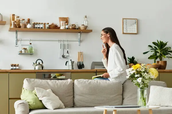 Young woman relaxes on the couch with a notebook, savoring a calm and cozy moment. — Stock Photo