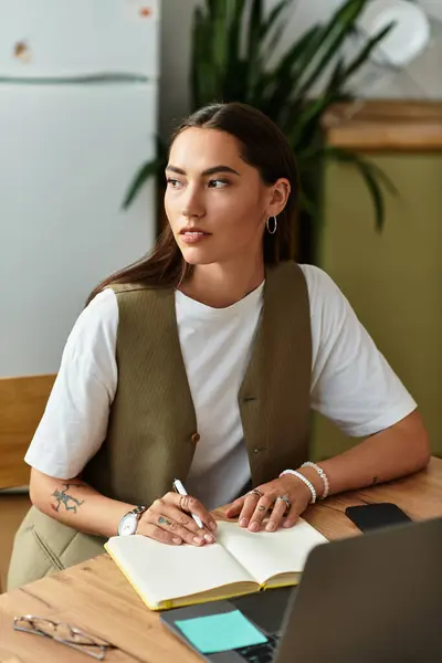 A woman sits at a wooden table, writing in her journal on a relaxed afternoon at home. — Stock Photo