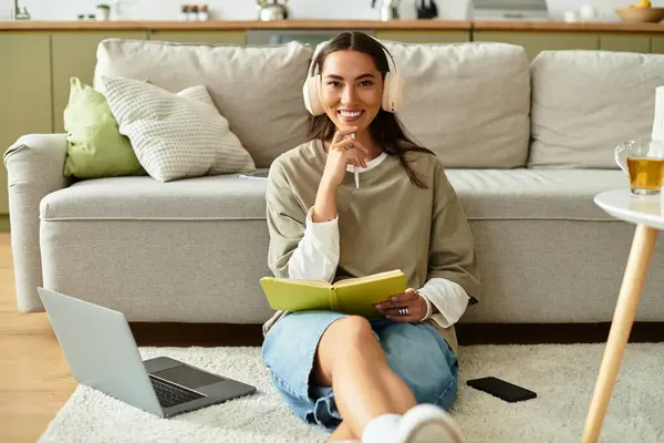 Bright and cozy atmosphere as a beautiful woman relaxes on the floor, writing notes while listening. — Stock Photo