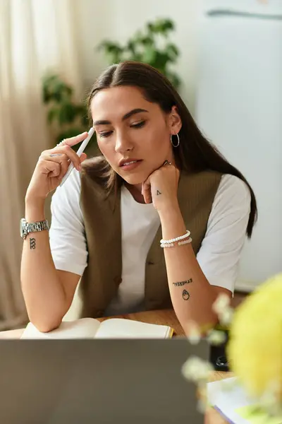 A young, pretty woman thoughtfully engages in her work at home, surrounded by a warm atmosphere. — Stock Photo