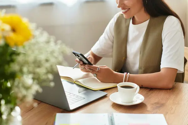 Young woman relaxes at home, sipping coffee and checking her phone in a comfy space. — Stock Photo