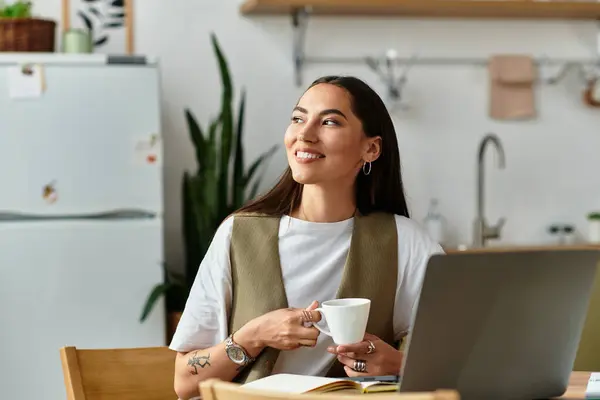Brightly lit kitchen with a young woman savoring coffee while smiling and relaxing at her table — Stock Photo