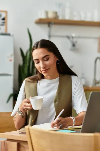 A young woman enjoys coffee and notes in her cozy home workspace. — Stock Photo
