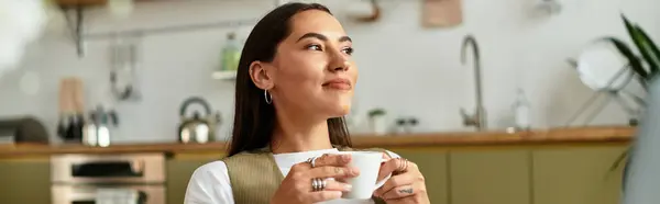 Young woman enjoys a warm cup of coffee while embracing the comfort of her home space. — Stock Photo