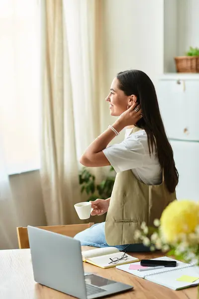 A beautiful young woman sits comfortably at home, reflecting on her day with a warm drink in hand. — Stock Photo