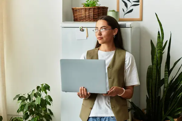 A young, pretty woman relaxes at home, engaged with her laptop, exuding tranquility. — Stock Photo