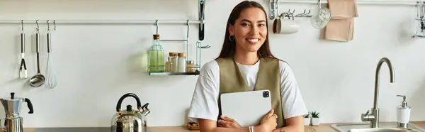 Beautiful young woman embraces a relaxing atmosphere at her home while holding a tablet. — Stock Photo