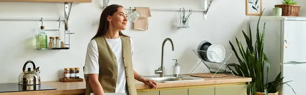 A young woman relaxes in her stylish kitchen, embracing a cozy atmosphere filled with homey details. — Stock Photo