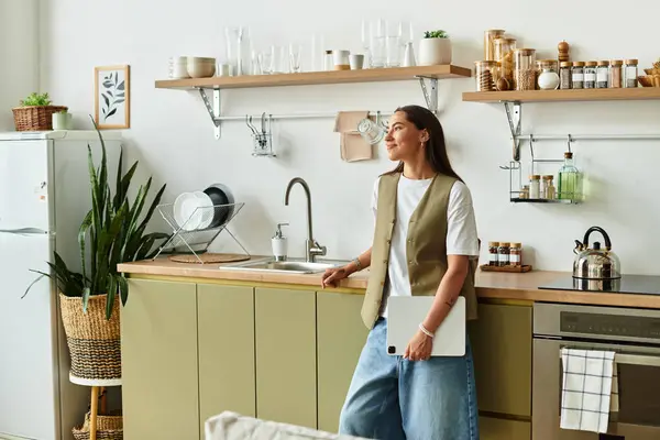 Beautiful young woman relaxes in her modern kitchen, savoring the comforts of home. — Stock Photo