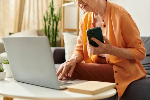 Content senior woman in comfy clothes enjoys technology at home. — Stock Photo