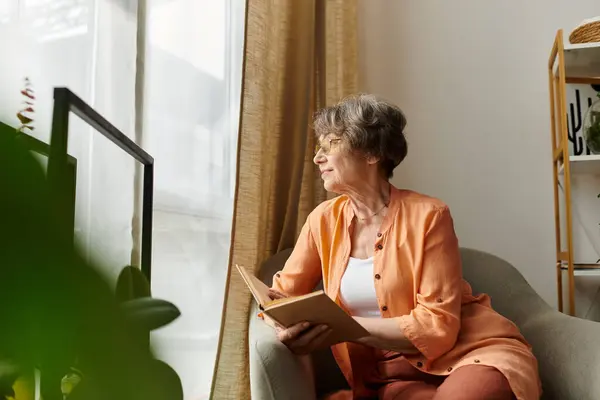 A cozy woman relaxes at home, engrossed in a book during her peaceful moment. — Stock Photo