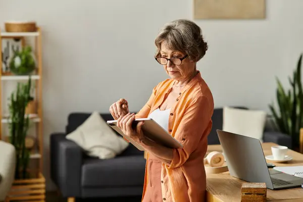 A senior woman in cozy attire stands thoughtfully in her warm and inviting living space. — Stock Photo