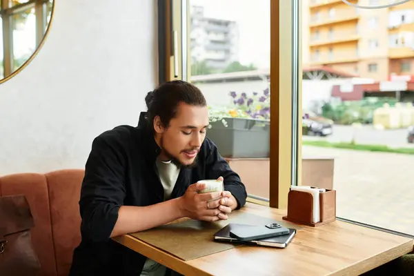 A young man with a beard savors his matcha in a cafe. — Stock Photo