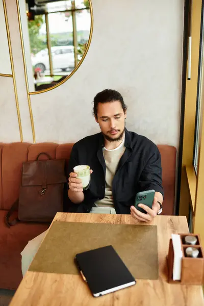 Young man with a beard balances remote work and relaxation in a vibrant cafe during summer. — Stock Photo