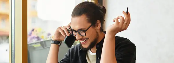 Freelancer se dedica a una animada conversación telefónica en un entorno de cafetería brillante, pancarta — Stock Photo