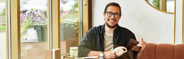 Young man with a beard smiles while enjoying matcha at a cafe during summer, banner — Stock Photo