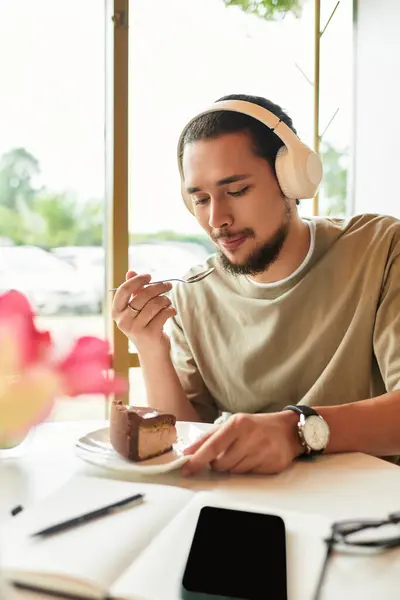 Young man indulges in cake and matcha while relaxing in cafe setting. — Stock Photo