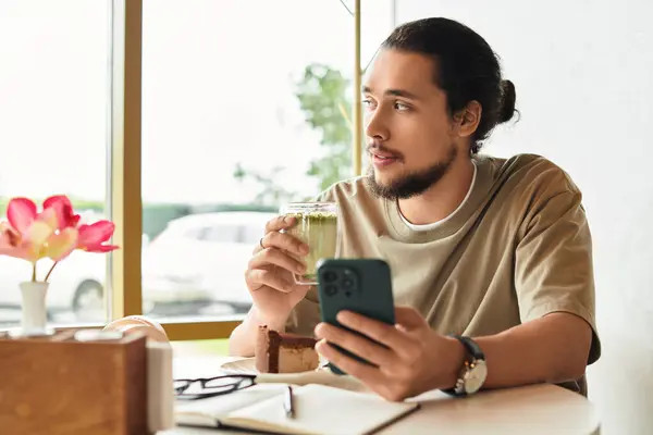 Freelancer in a relaxed cafe setting sips matcha and documents ideas while enjoying cake. — Stock Photo