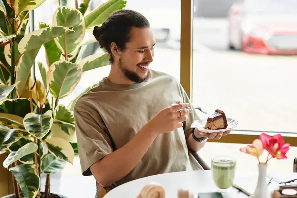 A young man with a beard savors a piece of cake — Stock Photo