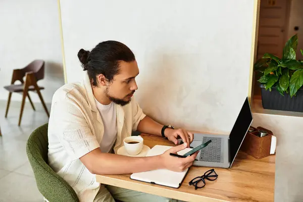 A young man with a beard engages in remote work while enjoying coffee at a cafe. — Stock Photo