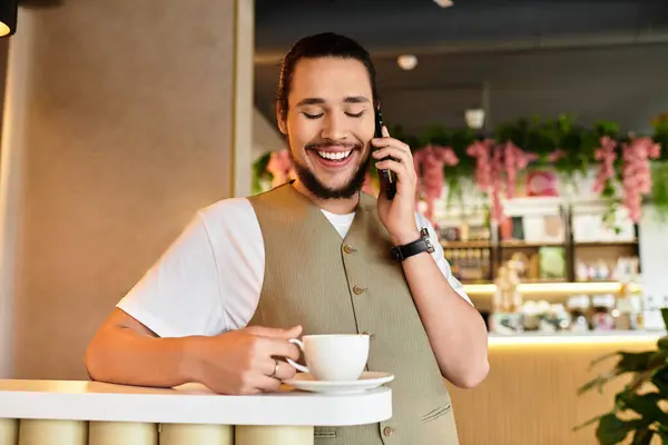 Un joven felizmente ocupado en el trabajo remoto mientras toma café en un animado café. — Stock Photo