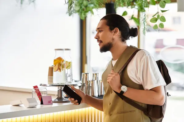 A young man with a beard talking in a stylish cafe, ordering coffee — Stock Photo