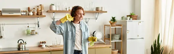 A young man enthusiasm shows as he cleans his modern kitchen, feeling proud of his tidy space. — Stock Photo
