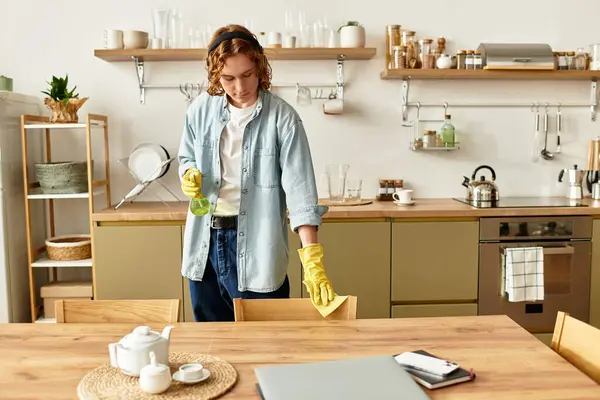 A young man in a stylish outfit is diligently cleaning his kitchen, bringing order to the space. — Stock Photo