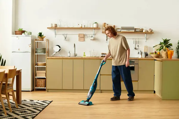 Un joven guapo limpia su cocina moderna, inmerso en una rutina productiva de la tarde. — Stock Photo