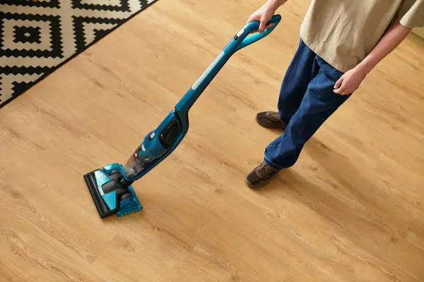 Handsome young man enjoys cleaning his living space while staying comfortably dressed. — Stock Photo