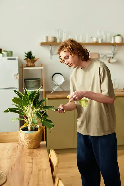 Un joven cuida amorosamente de sus plantas de interior con atención y entusiasmo en casa. - foto de stock