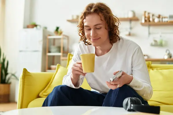 Young man relaxes at home, savoring a warm drink and enjoying his peaceful surroundings. — Stock Photo
