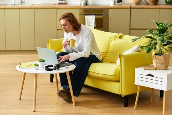 Enjoying a warm drink while working on a laptop in a bright and inviting space. — Stock Photo