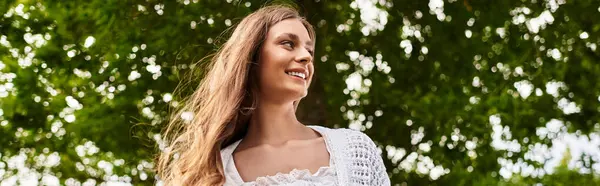 Beautiful young woman smiles as she relaxes during a picnic in a vibrant park setting. — Stock Photo