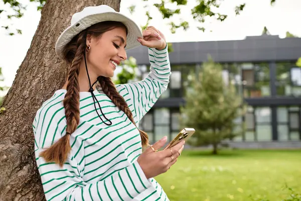 Relaxing outdoors in a park, a young woman enjoys her picnic while checking her smartphone. — Stock Photo