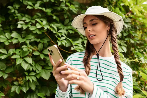 A young beautiful woman relaxes outdoors in a park, enjoying a picnic while using her phone. — Stock Photo