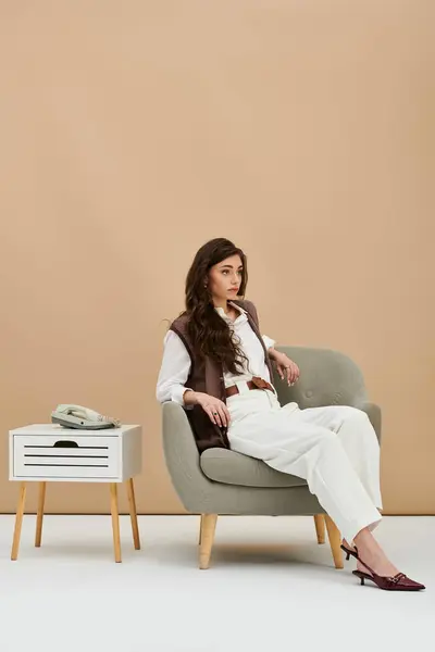 A beautiful young woman with long brown hair showcases trendy fashion in a chic studio environment. — Stock Photo