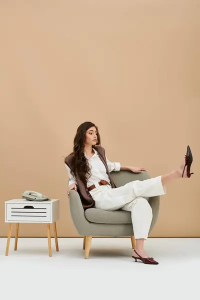 A confident young woman showcases her fashion sense in a chic outfit during a studio shoot. — Stock Photo