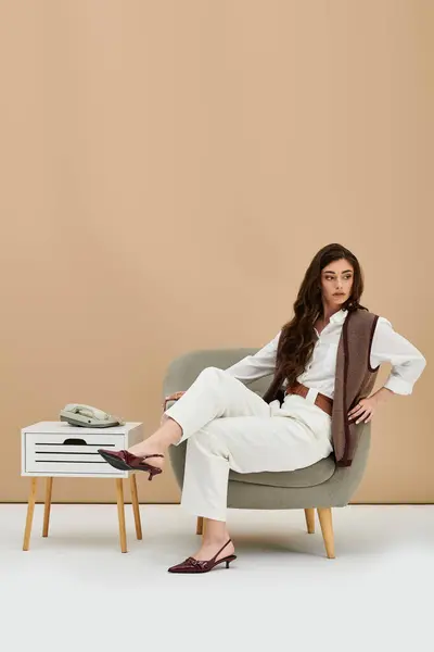 A young woman with long brown hair models fashionable attire in a chic studio environment. — Stock Photo