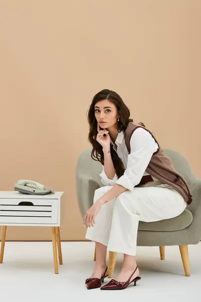 A stylish young woman with long brown hair poses thoughtfully in a contemporary studio setting. — Stock Photo