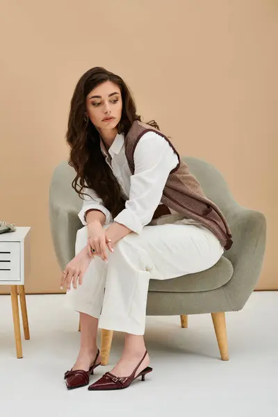 A young woman relaxes in a chic studio, flaunting her trendy outfit. — Stock Photo