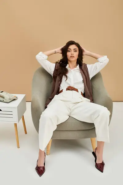 A young woman with long brown hair showcases her stylish attire in a chic studio space. — Stock Photo