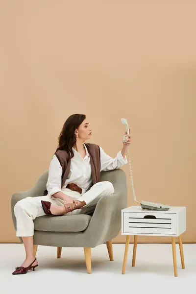 A beautiful young woman showcases her fashion sense in a chic studio, holding a vintage phone. — Stock Photo