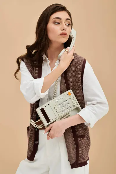 A beautiful young woman in fashionable attire engages in a conversation while holding a phone. — Stock Photo