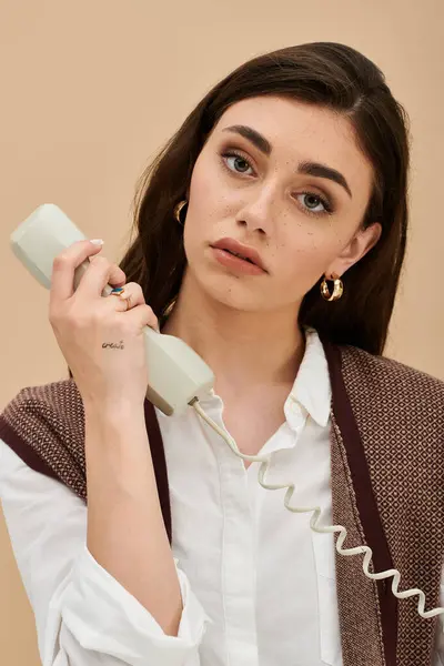 A stylish young woman poses thoughtfully with a vintage phone in hand. — Stock Photo