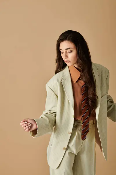Beautiful young woman with long brown hair models a chic suit and tie, exuding confidence and grace. — Stock Photo