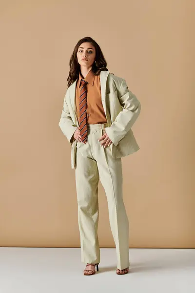 A beautiful young woman with long brown hair showcases her fashionable attire in a studio setting. — Stock Photo