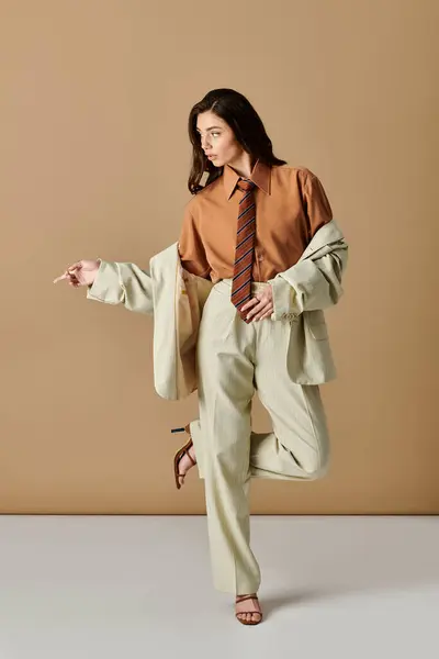 A beautiful young woman showcases her fashion sense in a stylish suit within a studio setting. — Stock Photo